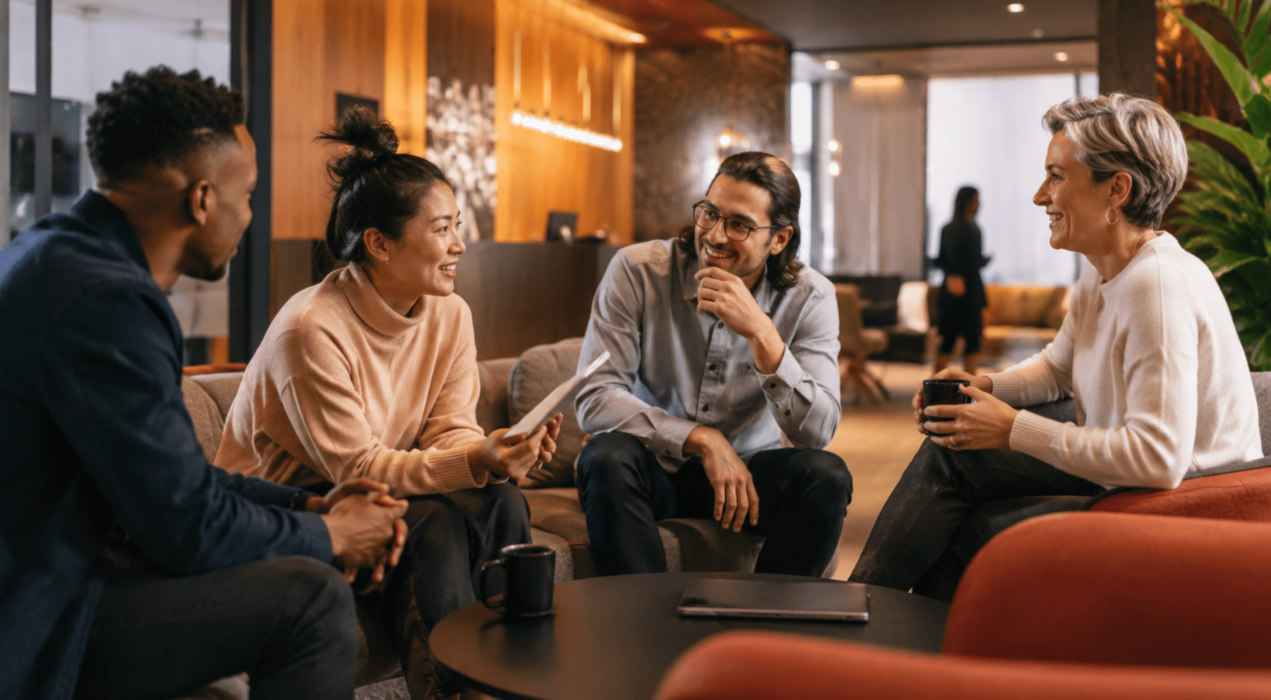 Team of professionals having an informal business discussion in a modern office lounge