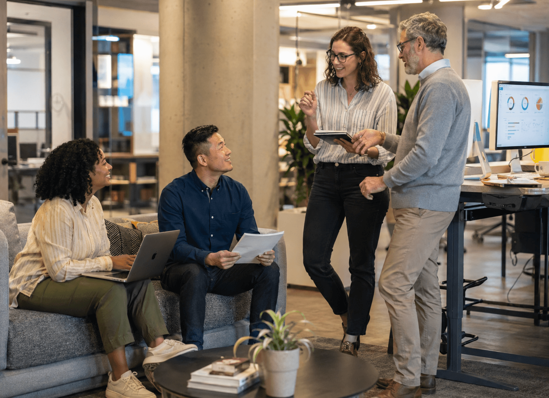 Colleagues collaborating and discussing ideas in a modern office workspace.